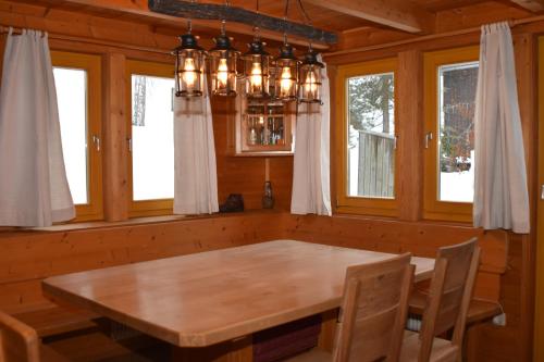 VerditzVerditzhütte的一间带木桌和吊灯的用餐室