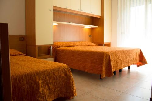 卡奥莱Hotel Kennedy的酒店客房带两张带橙色毯子的床