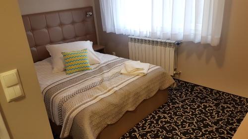 Wysokie MazowieckieHotel Gutland的一间卧室配有一张带枕头和窗户的床