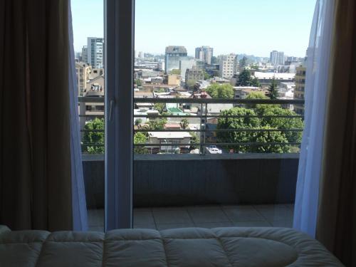 康塞普西翁Departamento Concepción Centro的带沙发的窗户享有城市美景。