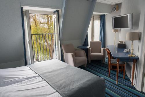 恩克赫伊曾克里夫港的配有一张床、一张书桌和一扇窗户的酒店客房