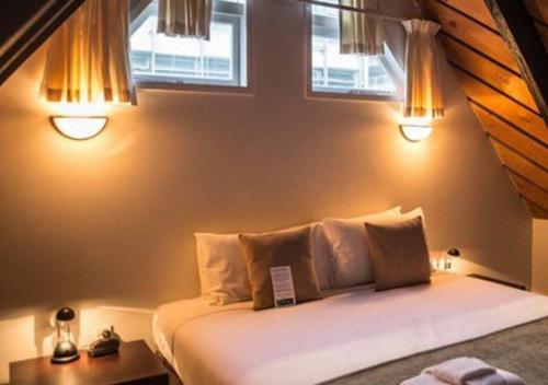 惠灵顿威利斯村酒店的一间卧室配有一张带两个窗户的床