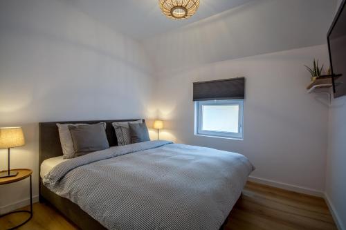 法尔肯堡Guesthouse 115的一间卧室设有一张大床和一个窗户。