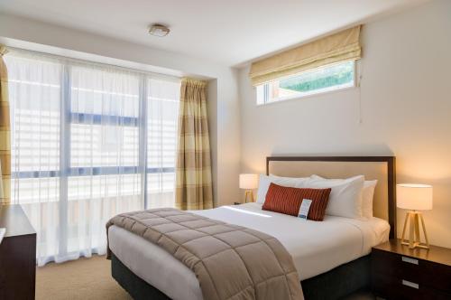 惠灵顿布考特套房酒店的一间卧室设有一张床和一个大窗户