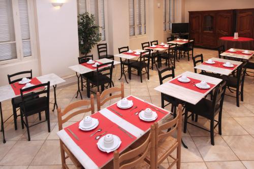 尼斯托卡德罗酒店的用餐室配有桌椅和红色餐巾