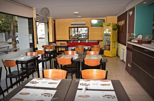 贝纳多图埃托Hotel San Marino的餐厅内带桌椅的用餐室