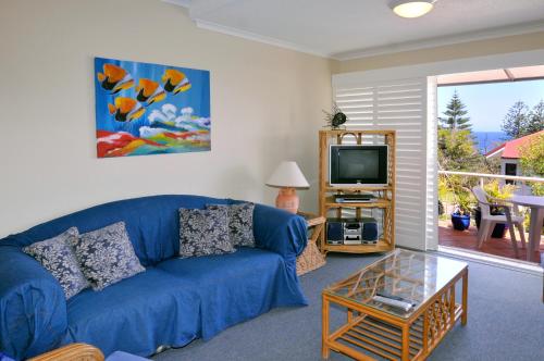 阳光海岸Bright & comfortable in quiet location的客厅配有蓝色的沙发和电视