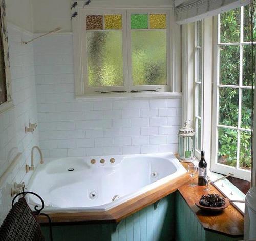 卢拉Lemon Tree Cottage的带浴缸的浴室和2个窗户