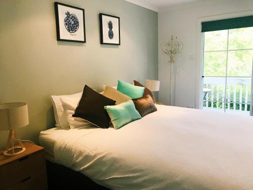 BurradooBowral Escape的卧室配有白色的床和枕头。