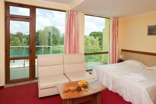 普里莫尔斯科Perla Sun Beach Hotel - All Inclusive的酒店的客房 - 带一张床、椅子和窗户