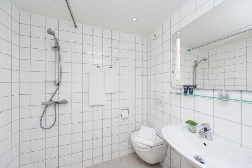 勒兹维Hotel Klinten的带淋浴和卫生间的白色瓷砖浴室