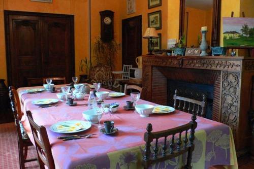 Chaumontel布维里尔庄园酒店的餐桌、粉红色桌布和壁炉