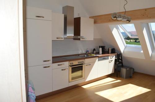 赖兴瑙Zum Talhof的厨房配有白色橱柜和炉灶烤箱。