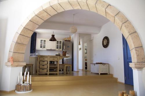 GrikosLuxury house in the island of Patmos的厨房里的拱门,配有桌子和柜台