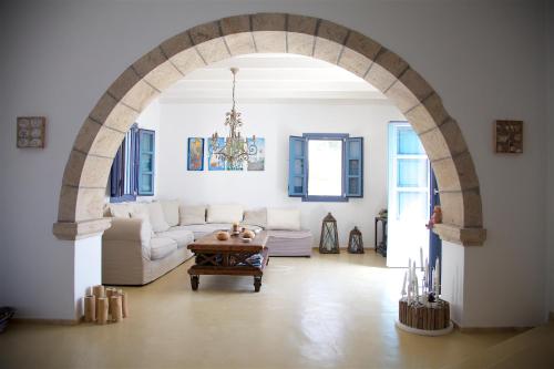 GrikosLuxury house in the island of Patmos的带沙发和桌子的客厅的拱门