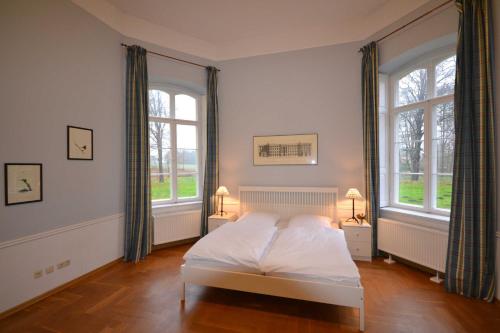 WalkendorfFerienGut Dalwitz Gutshaus的卧室配有白色的床和2扇窗户。