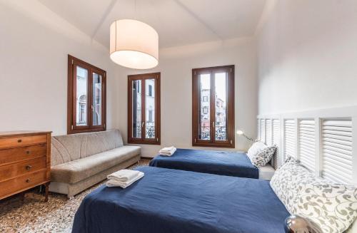 威尼斯Ca' d'Oro suite的一间带两张床和一张沙发的客厅