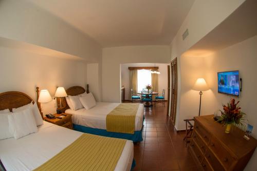 巴里奥斯港Amatique Bay Hotel的酒店客房设有两张床和一张桌子。