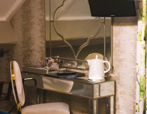 巴利米纳雷恩摩尔酒店的客房设有带花瓶和镜子的书桌