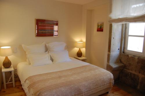 波尔图托普弗兰特酒店的卧室配有带白色枕头的床和窗户。