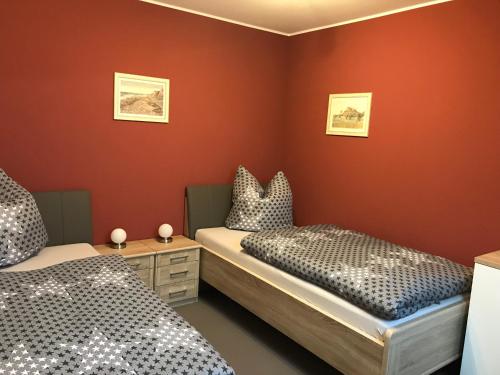 鲁贝兰德Ferienwohnung Am Burgberg的红色墙壁客房的两张床