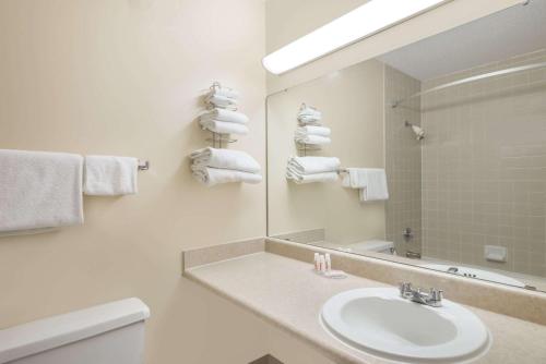 沃特敦Ramada by Wyndham Watertown Thousand的白色的浴室设有水槽和镜子