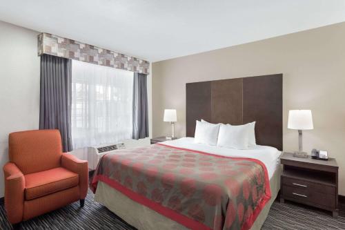 蒙特雷蒙特雷华美达汽车旅馆的配有一张床和一把椅子的酒店客房