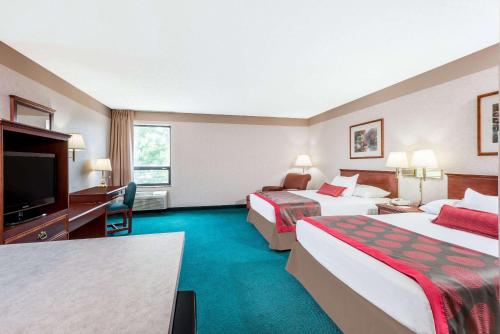 StrasburgRamada by Wyndham Strasburg Dover的酒店客房设有两张床和一台平面电视。