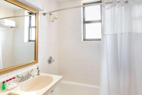泽西市泽西市华美达酒店的白色的浴室设有水槽和镜子
