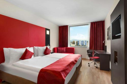 日内瓦Ramada Encore by Wyndham Geneva的配有一张床、一张书桌和一扇窗户的酒店客房