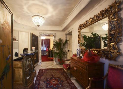 罗马杜斯别墅酒店的一间带镜子和梳妆台的客厅和一间房间