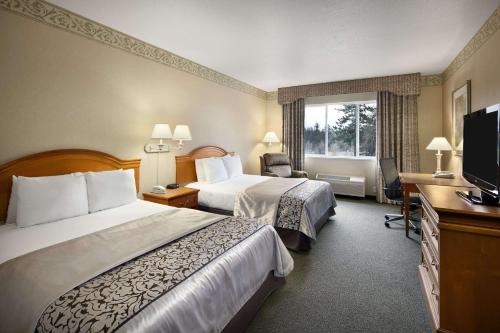 奥林匹亚奥林匹亚华美达酒店的酒店客房设有两张床和一台平面电视。