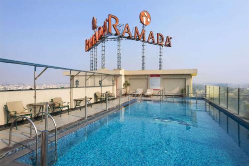 贾朗达尔Ramada by Wyndham Jalandhar City Center的一座位于酒店顶部的带有标志的游泳池