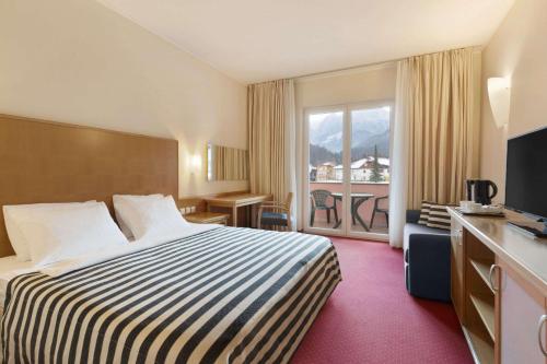 克拉尼斯卡戈拉克拉尼斯卡戈拉华美达酒店及套房的酒店客房设有一张床和一个阳台。