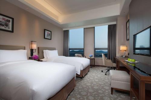 济南济南银丰华美达酒店的酒店客房设有两张床和一台平面电视。