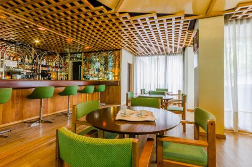 圣胡利娅-德洛里亚圣埃洛伊酒店的一间带桌椅的餐厅和酒吧