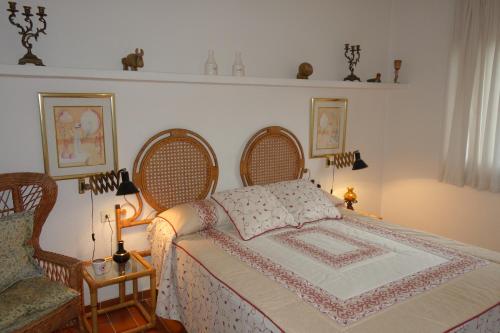 卡莱利亚德帕拉弗鲁赫尔Apartament Calella Park的一间卧室配有一张床、两把椅子和一把椅子