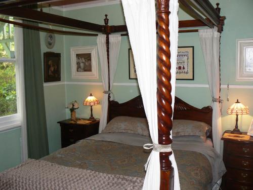 卢拉Lemon Tree Cottage的一间卧室配有四柱床和两盏灯。