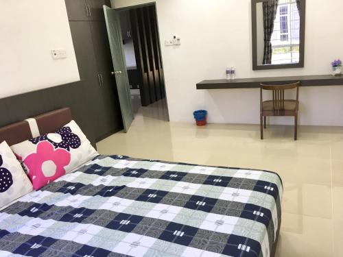 拉布安甘加拉之家度假屋的卧室配有1张床、1张桌子和1把椅子