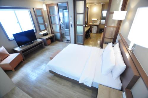 高雄康桥商旅 - 汉神馆的酒店客房,配有床和电视