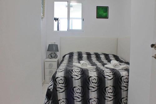 卡尔佩Apartamento Horizonte的一间卧室配有一张带黑白色棉被的床