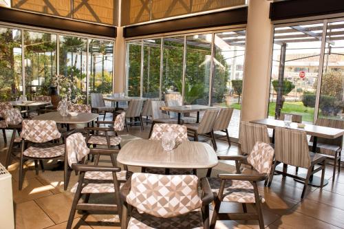 阿格里尼翁阿格里尼翁帝国酒店的餐厅设有桌椅和窗户。