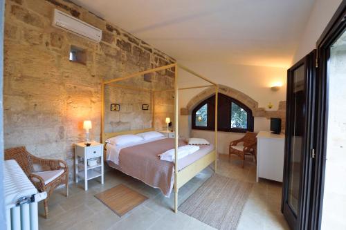 穆罗莱切塞马塞里亚拉哥酒店的一间卧室设有一张床和石墙