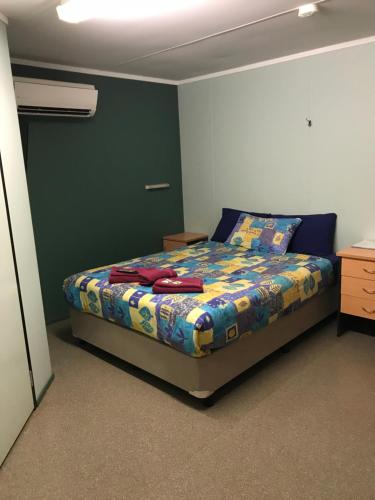 卡拉萨卡拉萨TWA公寓式酒店的一间卧室配有一张带五颜六色棉被的床