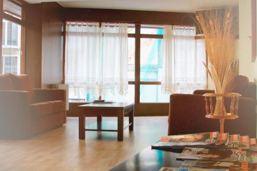 拉科鲁尼亚Hotel Santa Catalina by Bossh Hotels的客厅配有沙发和桌子