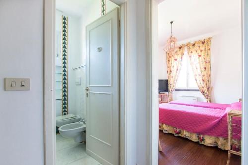 马尔米堡Villa Rita的一间带粉红色床的卧室和一间浴室