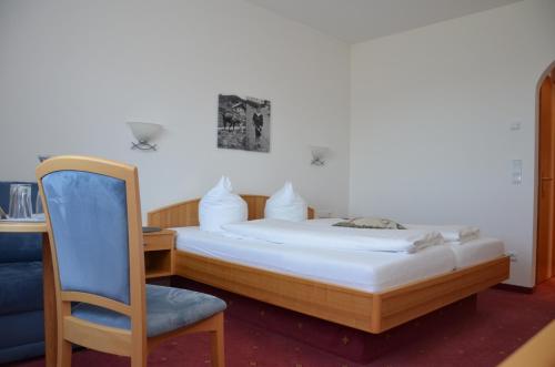 Sibratsgfäll赫斯臣旅馆的一间卧室配有一张带椅子的床和一张书桌