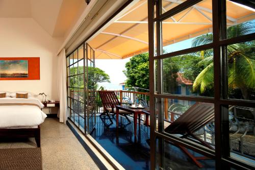 科钦Eighth Bastion Fort Kochi - CGH Earth的客房设有一张床,享有阳台的景致。