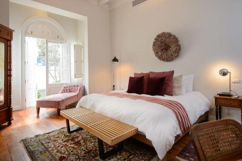 利马Villa Barranco by Ananay Hotels的一间卧室配有一张大床和一把椅子