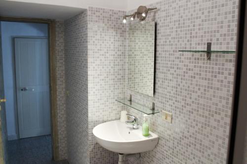 费拉约港Bed & Bike Casa dei Papi的白色的浴室设有水槽和镜子